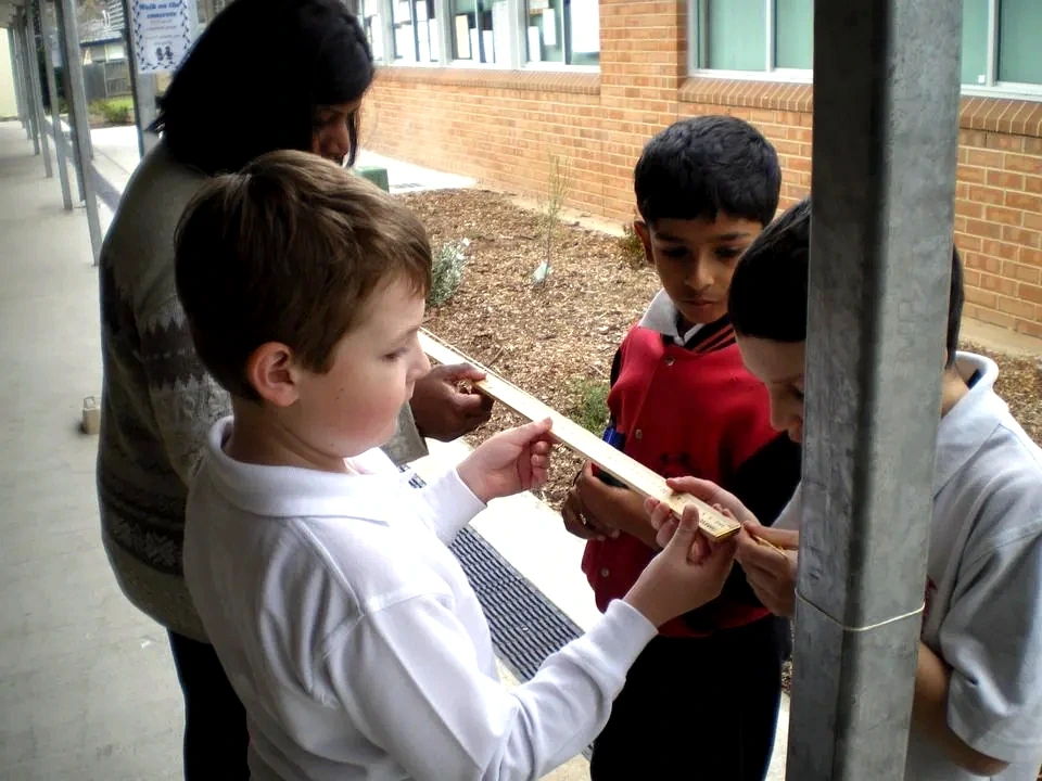 Students making careful measurements during an outdoor investigation